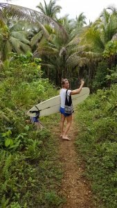 met surfplank door de jungle