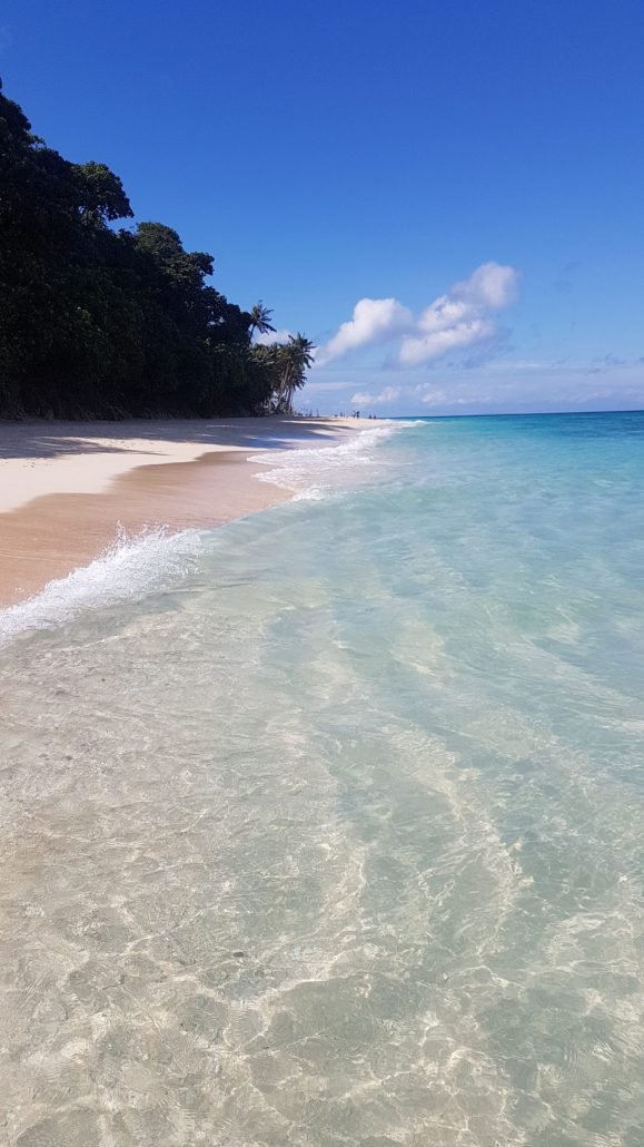 wit strand, blauw water en palmbomen