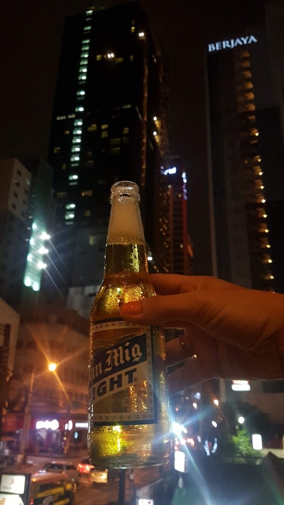 cheers with beer and big building makati